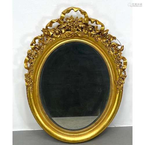 DECORATIVE FLORAL RIBBON GILT OVAL FRAME MIRROR.