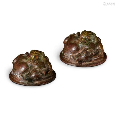 A pair of embellished gold and silver-inlaid bronze weights,...