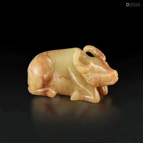 A small yellow and russet jade figure of a recumbent buffalo...