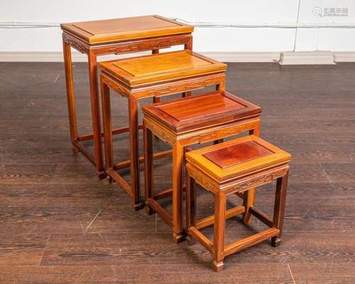 A rosewood set of four nesting tables.