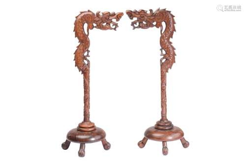 A close pair of Chinese carved wood lantern stands in the fo...