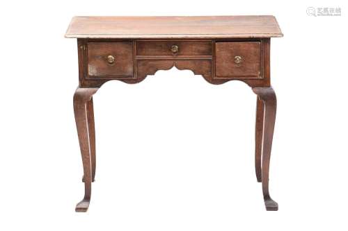 An early 18th-century oak kneehole lowboy with moulded top a...
