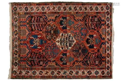 A Baktiari rug, the red ground filled with diamond lozenges ...