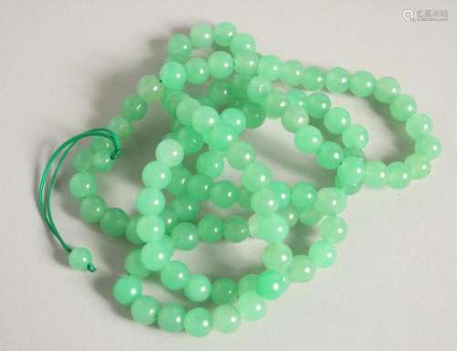 A STRING OF JADE BEADS 20ins long.