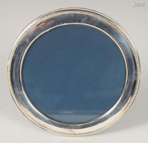A ROUND SILVER PHOTOGRAPH FRAME with bead edge. 6ins diamete...