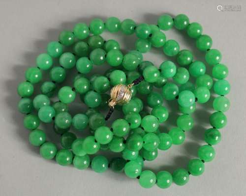 A GOOD STRING OF JADE PEARLS with gold and diamond clasp. 46...
