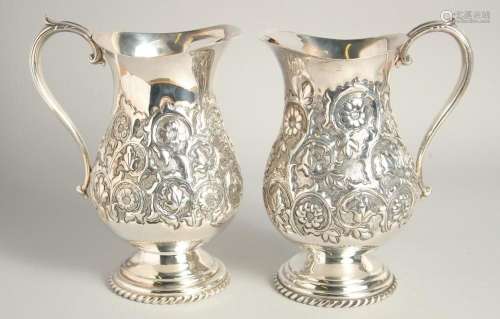 A GOOD PAIR OF CONTINENTAL SILVER PLATED WATER JUGS with flo...