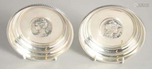 A SMALL PAIR OF SILVER PLATED CIRCULAR DISHES with cast hand...