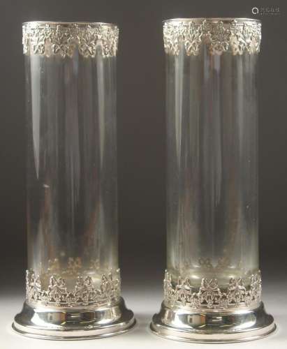A TALL PAIR OF PLAIN GLASS CIRCULAR VASES with silver bases ...
