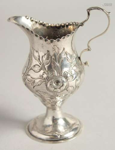 A GEORGE III SILVER CREAM JUG chased with flowers. London 17...