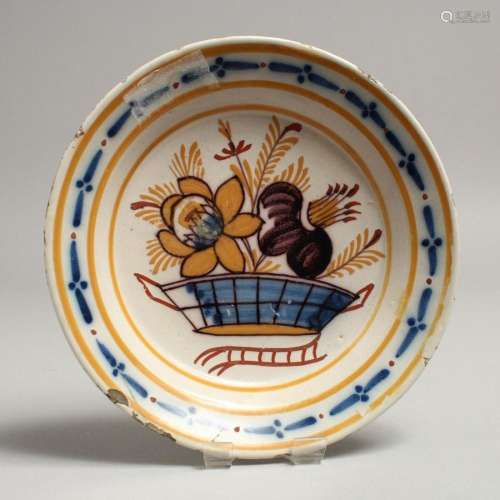 A SMALL TIN GLAZE CIRCULAR PLATE, decorated with a basket of...