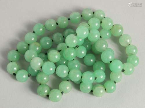 A STRING OF JADE BEADS 34ins long.