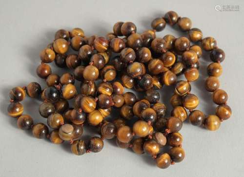 A STRING OF TIGER S EYE BEADS. 50ins long.