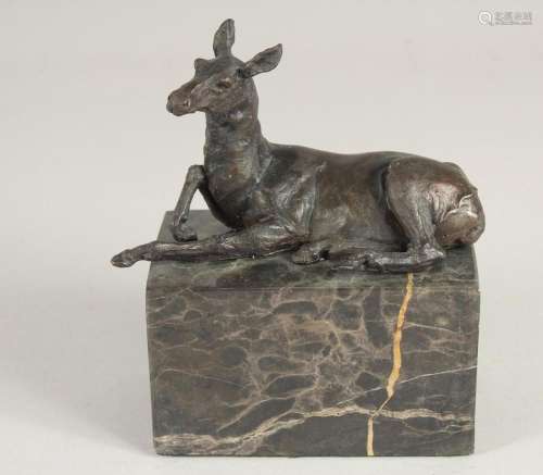 A SMALL BRONZE OF A DEER. 5.5ins long on a marble base.