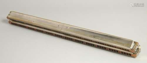 M. HOHNER. A LONG DOUBLE HARMONICA. 23ins long, in a case.