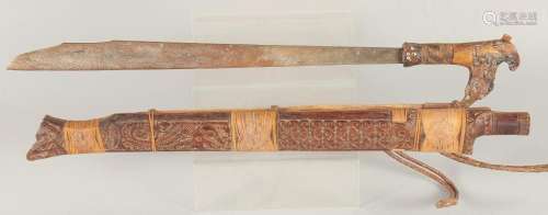 A BONE HANDLED KRIS SWORD in a wooden sheath. 2ft 4ins long.