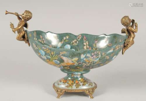 A BRONZE AND PORCELAIN OVAL BOWL with cherubs. 11ins long.