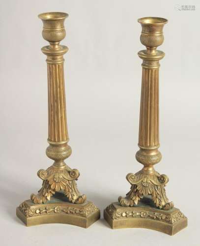 A PAIR OF EMPIRE ORNATE CANDLESTICKS on shaped triangular ba...