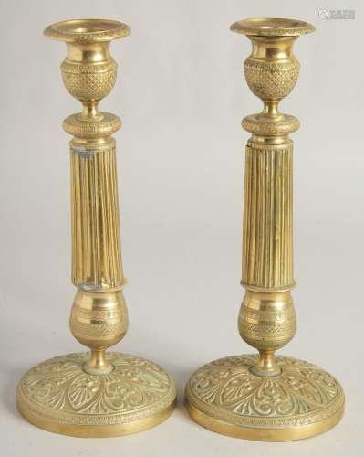 A PAIR OF EMPIRE ORNATE CANDLESTICKS on circular bases. 11in...