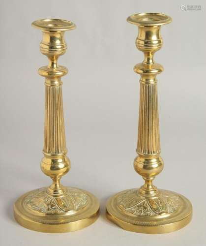 A PAIR OF EMPIRE ORNATE CANDLESTICKS on circular bases. 11in...