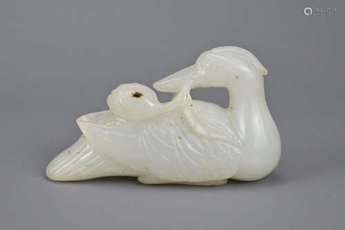 A CHINESE PALE CELADON JADE CARVING OF CRANE WITH LOTUS BRAN...