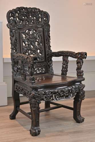 A CHINESE HARDWOOD ARMCHAIR, 19TH CENTURY. Heavily carved th...