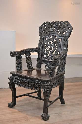 A CHINESE HARDWOOD ARMCHAIR, 19TH CENTURY. Heavily carved th...