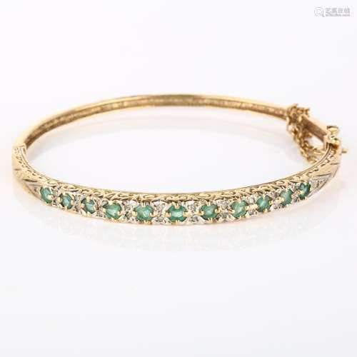 A 9ct gold emerald and diamond hinged bangle, set with round...