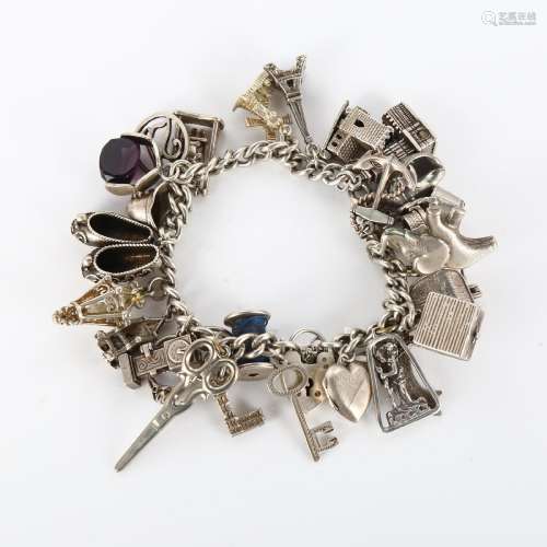 A silver curb link charm bracelet, with large quantity of ch...