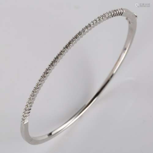 A modern 9ct white gold diamond hinged bangle, set with mode...
