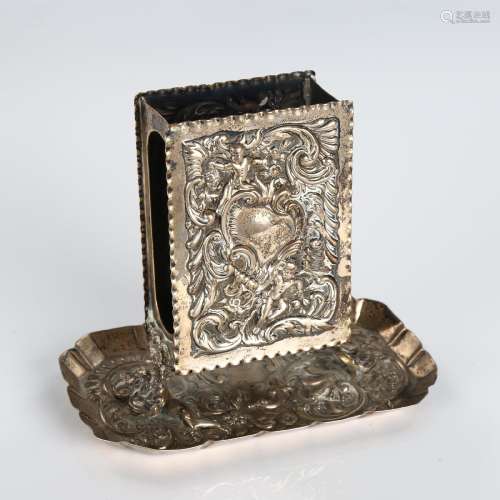 A late Victorian silver upright matchbox holder, relief embo...