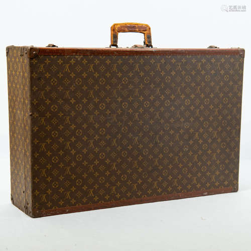 A large Louis Vuitton monogrammed canvas hard-sided suitcase...