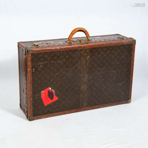 A medium Louis Vuitton monogrammed canvas hard-sided suitcas...