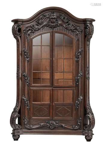 A large and abundantly decorated oak Rococo style display ca...