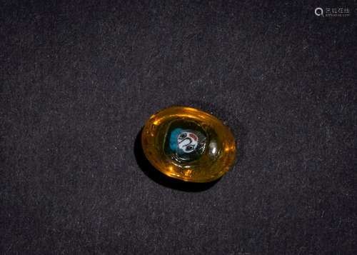 AN AMBER COLOURED GLASS PHOENICIAN FACE BEAD 5TH-4TH CENTURY...