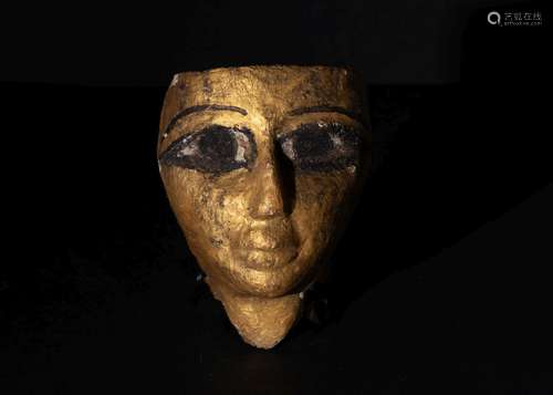 AN EGYPTIAN GILT WOOD SARCOPHAGUS MASK, NEW KINGDOM CIRCA, 1...