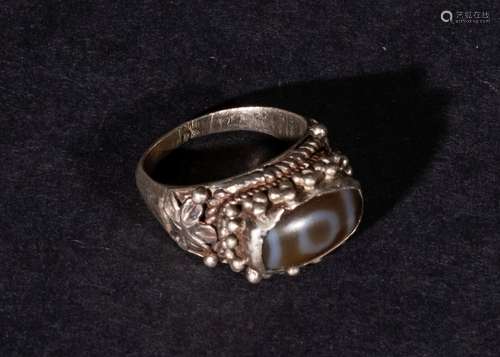 A DZI BEAD RING SET ON SILVER