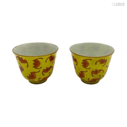 A pair of yellow ground cups, decorated with bats in iron-re...