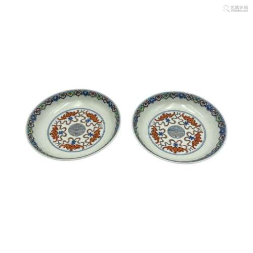 A pair of doucai dishes, the central roundel with an emblem ...
