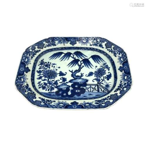 A blue and white serving plate, decorated with a fenced flow...