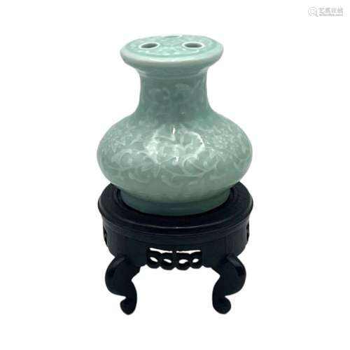 A Chinese celadon-glazed flower holder, all around carved wi...