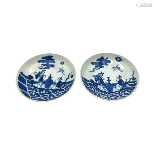 A pair of blue and white saucers, decorated with female Immo...