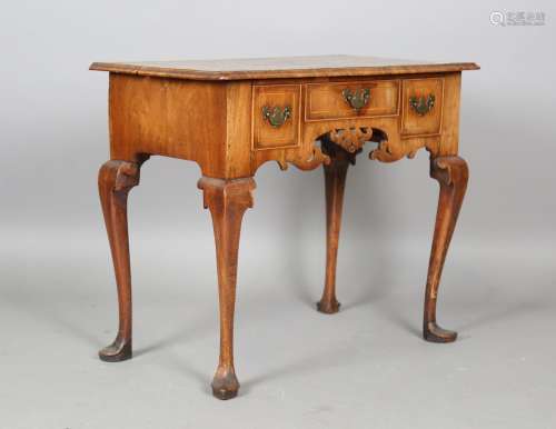 A George I walnut and crossbanded kneehole lowboy, fitted wi...