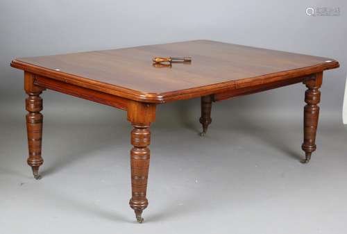 A late Victorian walnut extending dining table, the top fitt...