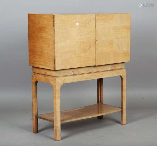 An Art Deco walnut cabinet, in the manner of Gordon Russell,...