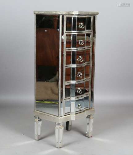 A modern mirrored and silvered chest of six drawers with sha...
