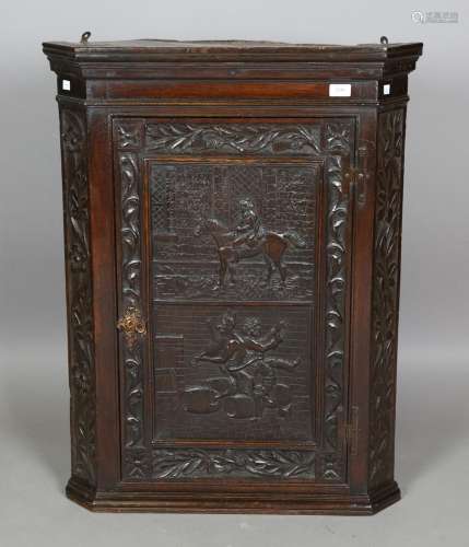 An 18th century provincial oak hanging corner cabinet, the p...