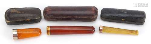Three amber coloured cheroot cigarette holders with fitted c...