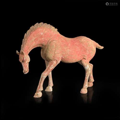 A Chinese red-painted grey pottery figure of a horse with lo...