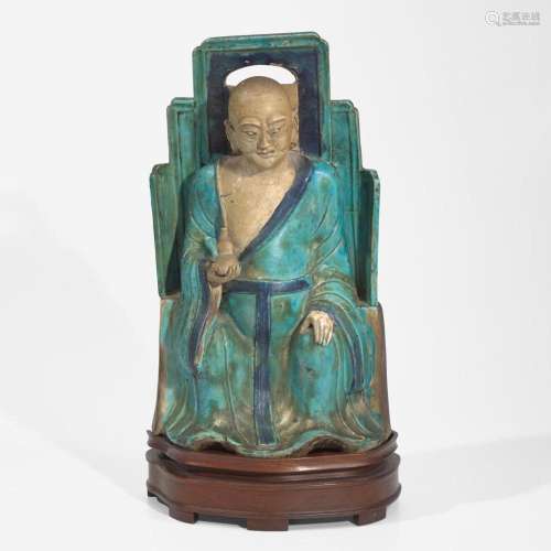 A Chinese turquoise and blue glazed figure of a seated Luoha...